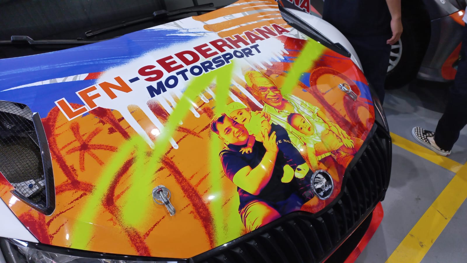 Tim Balap LFN Sederhana Motorsport Tutup Tahun 2023 Dengan Mengesankan Kap mesin salah satu mobil tim H. Rahmat beserta jajaran pebalap tim LFN Sederhana Motorsport dihias gambar keluarga H. Rahmat
