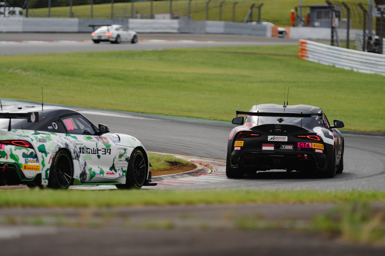 Haridarma dan Kazuhisa berupaya merebut posisi pertama di tengah lintasan yang licin akibat hujan